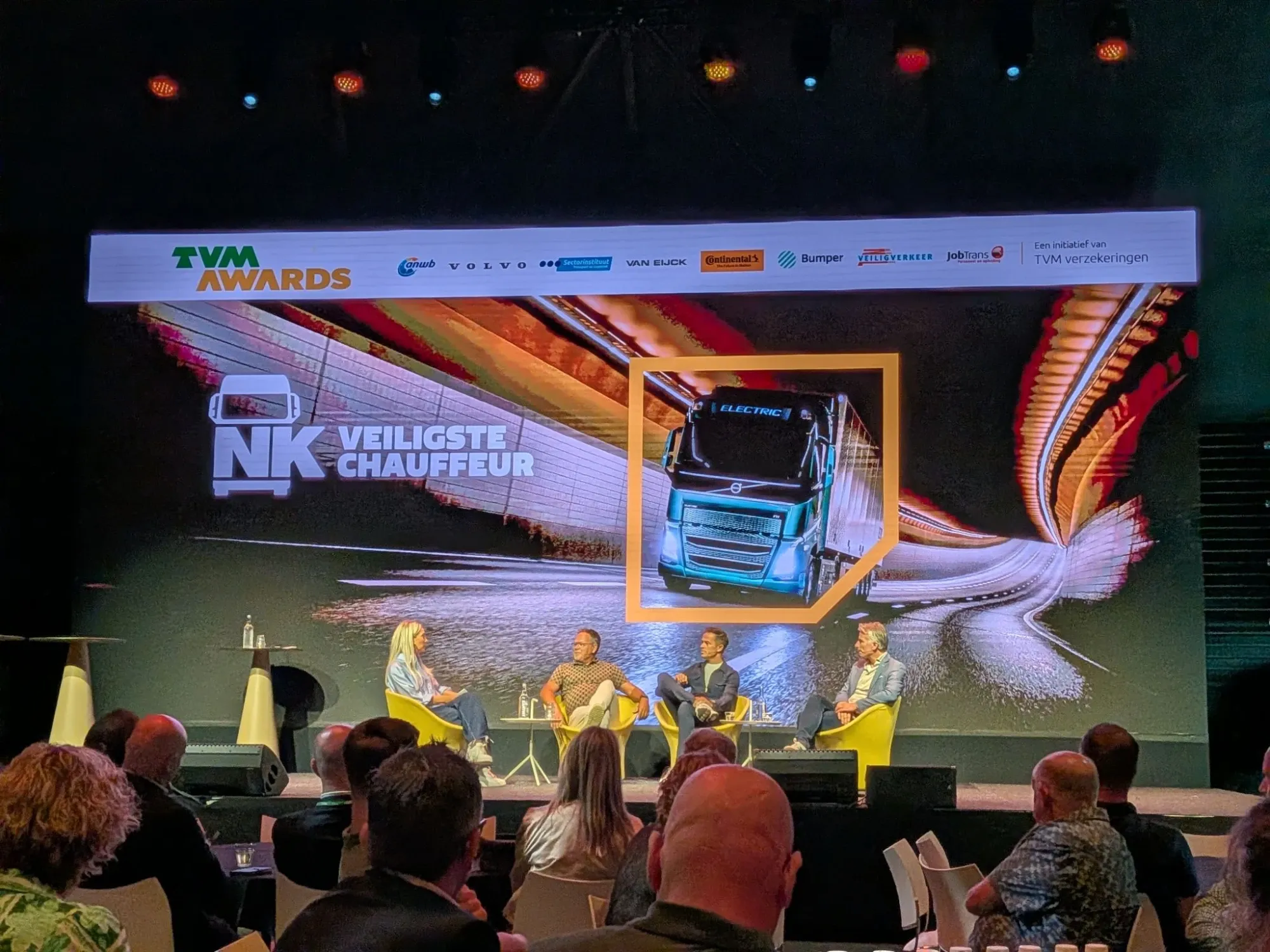 Panel discussion on stage at the TVM Awards and NK Veiligste Chauffeur, with the event partners on the screen above